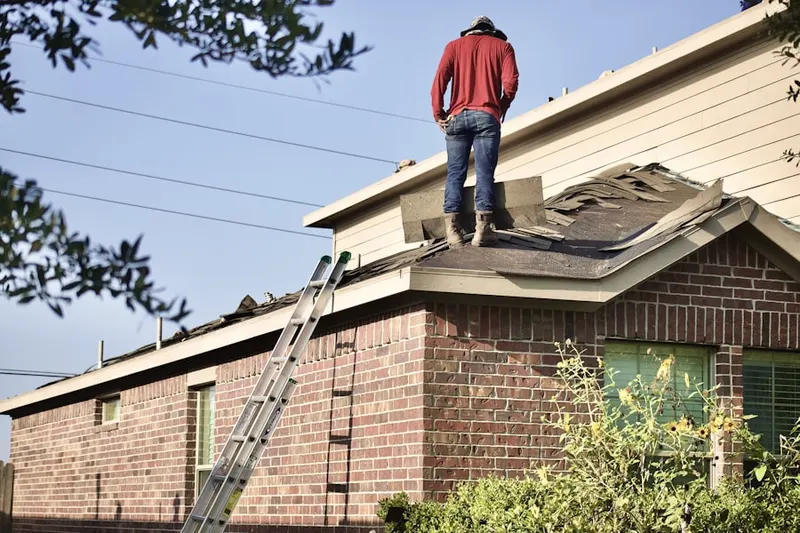 Professional roofer working on a residential roof in Strang Line
